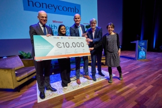 De winnaar poseert met de cheque